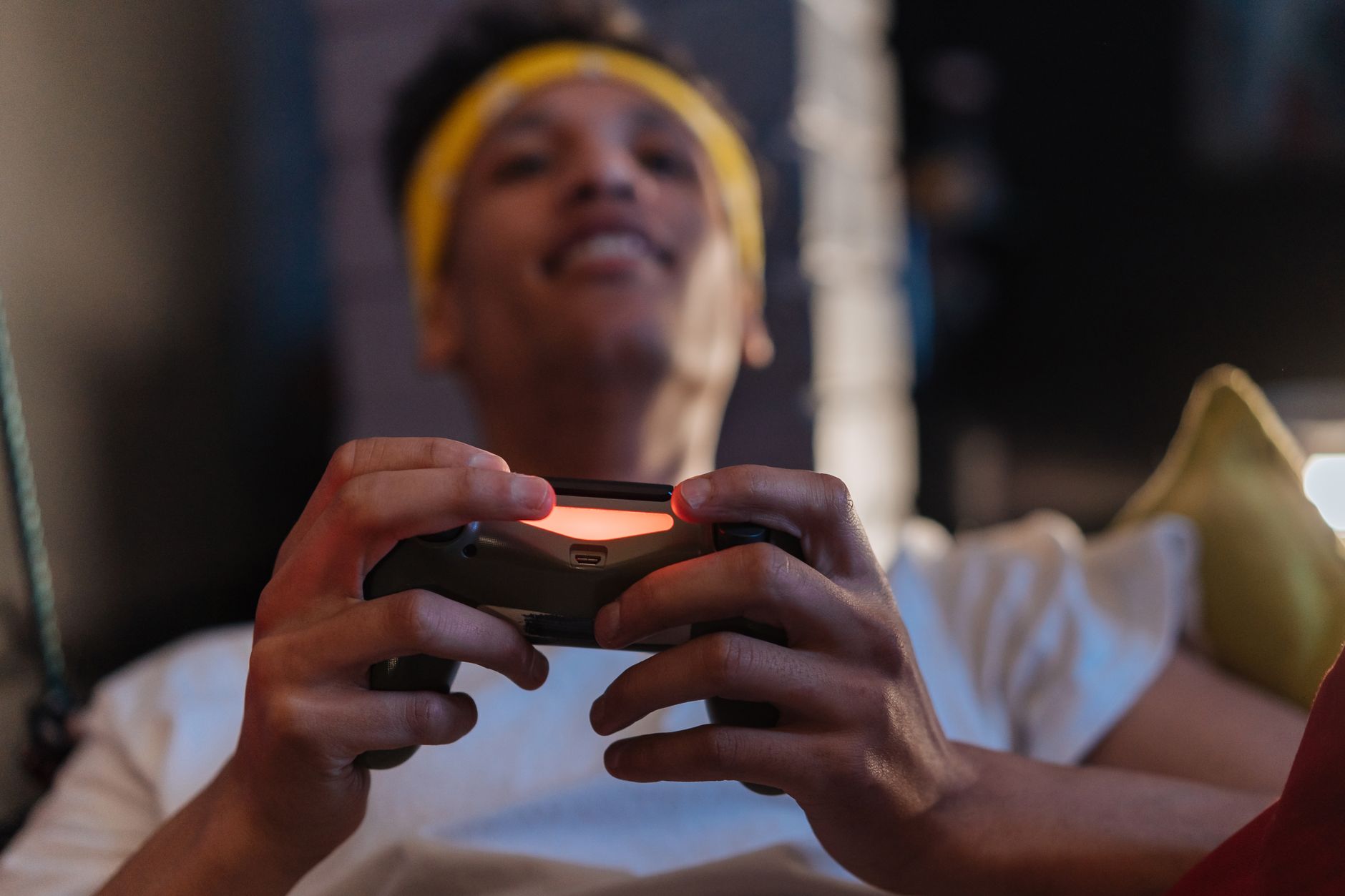 A relaxed gaming session with a close-up view of a man holding a game controller indoors. — How Sureman Helps Gamblers Avoid