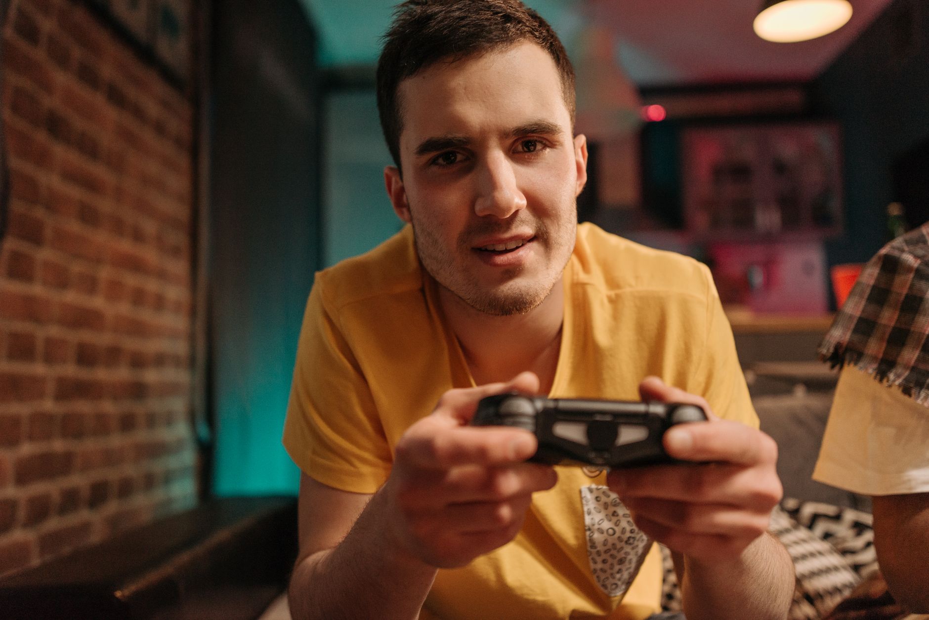 Focused young man enjoying video games with a controller indoors. — Wzrost kasyn z Blikiem: Trendy w grach online