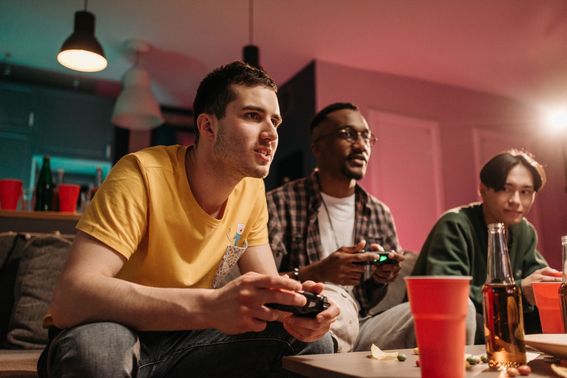 Diverse group of young adults playing video games on a cozy sofa with refreshments. — Wzrost kasyn z Blikiem: Trendy w grach